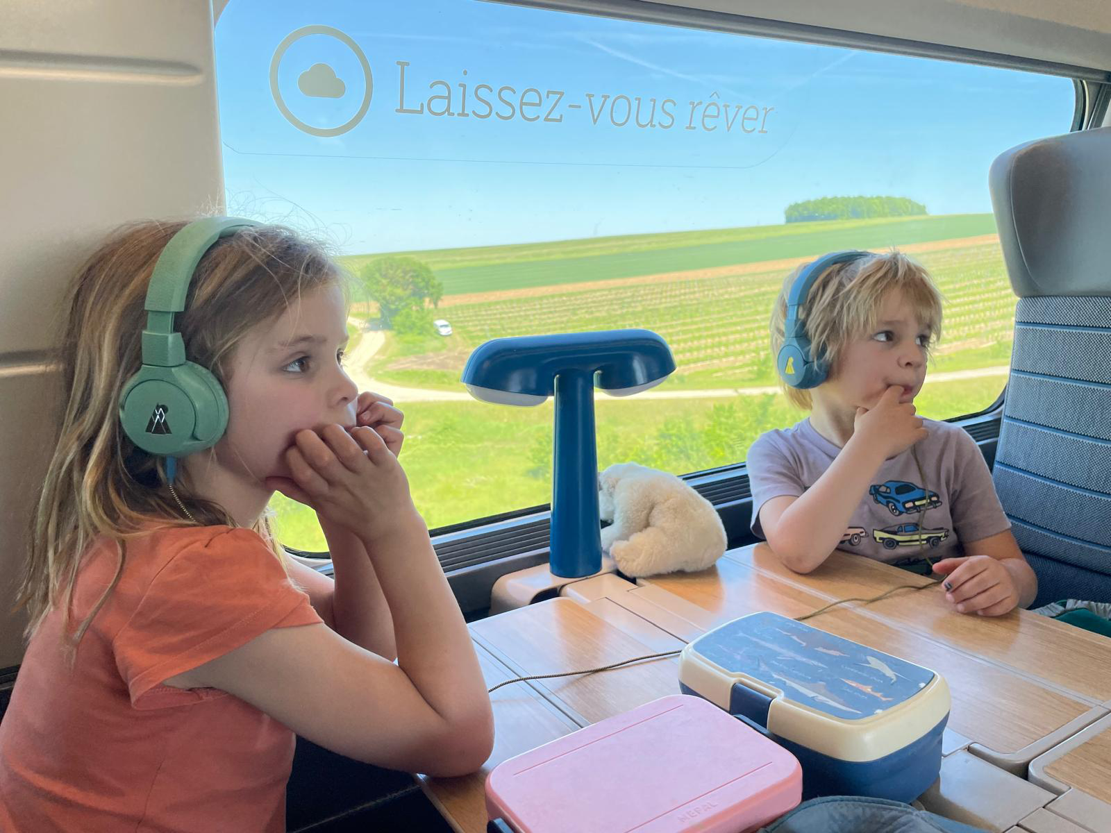 Two kids on a train wearing POGS